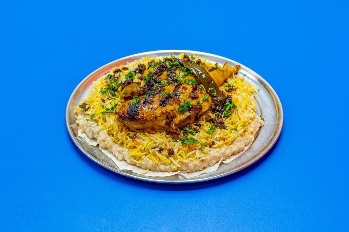Chicken mathlootha on a steel platter — grilled chicken over spiced rice, jareesh and lavash bread.