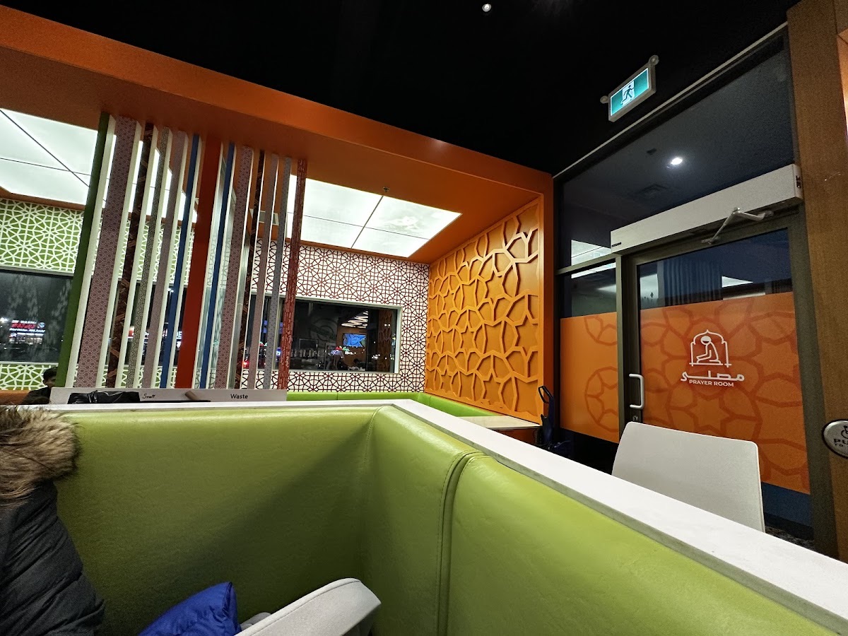 Inside our Mississauga dining room — orange laser-cut screens, patterned walls and green booths.